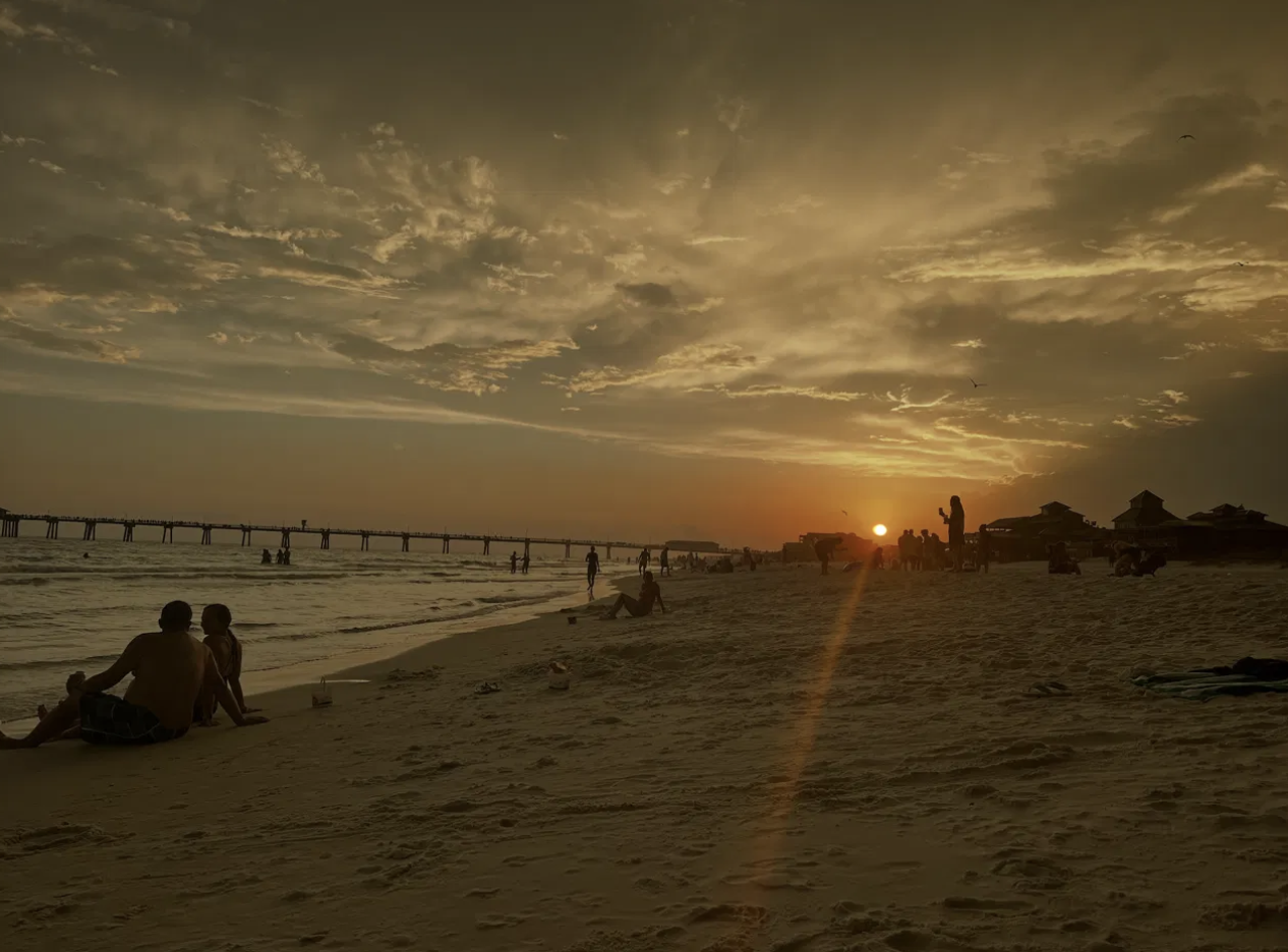 A sunset over the beach and pier on Florida's Emerald Coast, featured in a guide to sleep training and nighttime diapers.