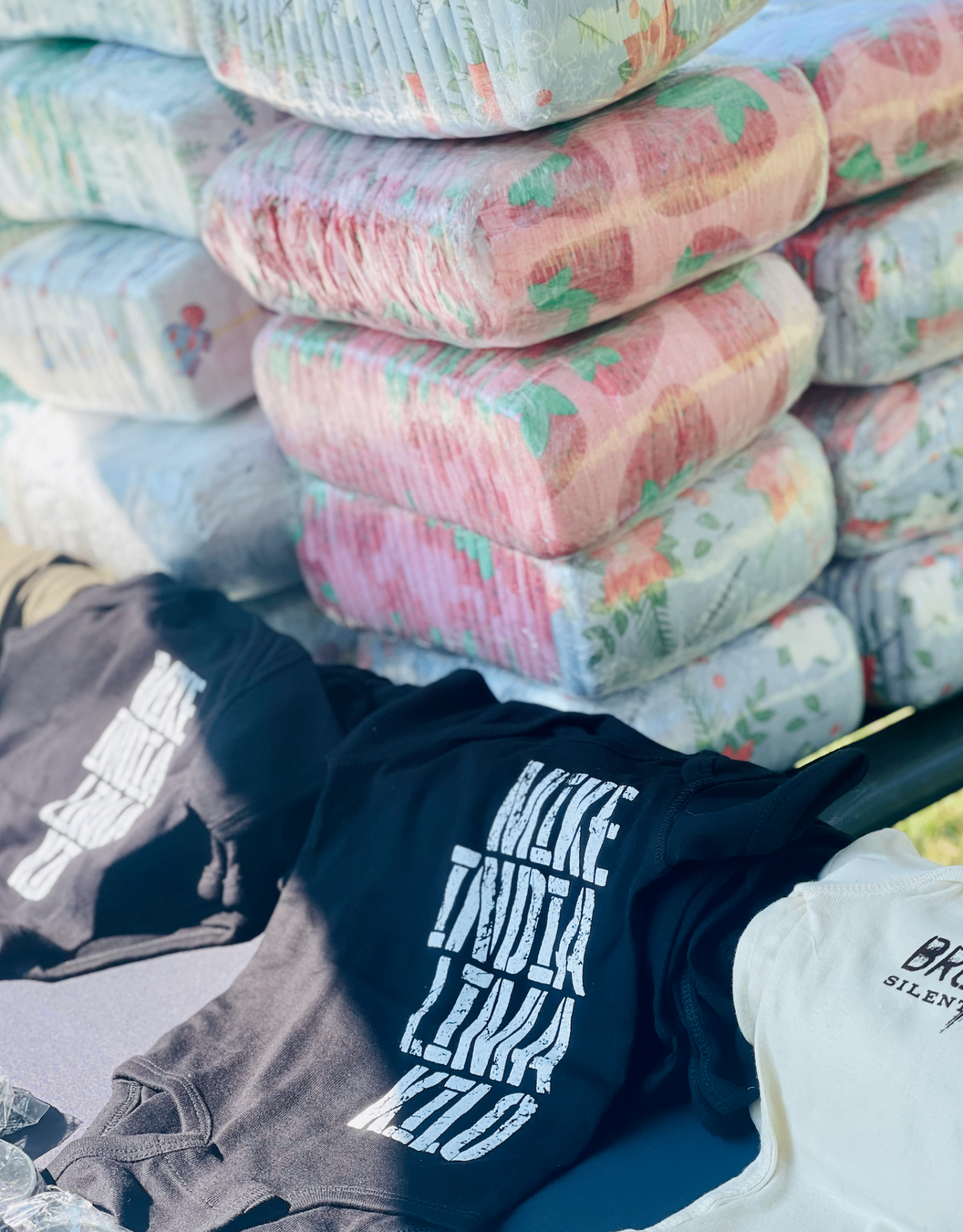 Stacks of packaged diapers and baby onesies at a military family event, featured in a guide to how much diapers cost.
