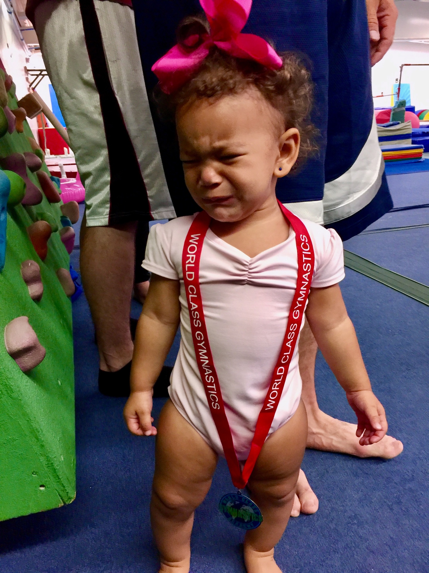A crying toddler at a gymnastics event, featured in a guide on how to know when to change a diaper.