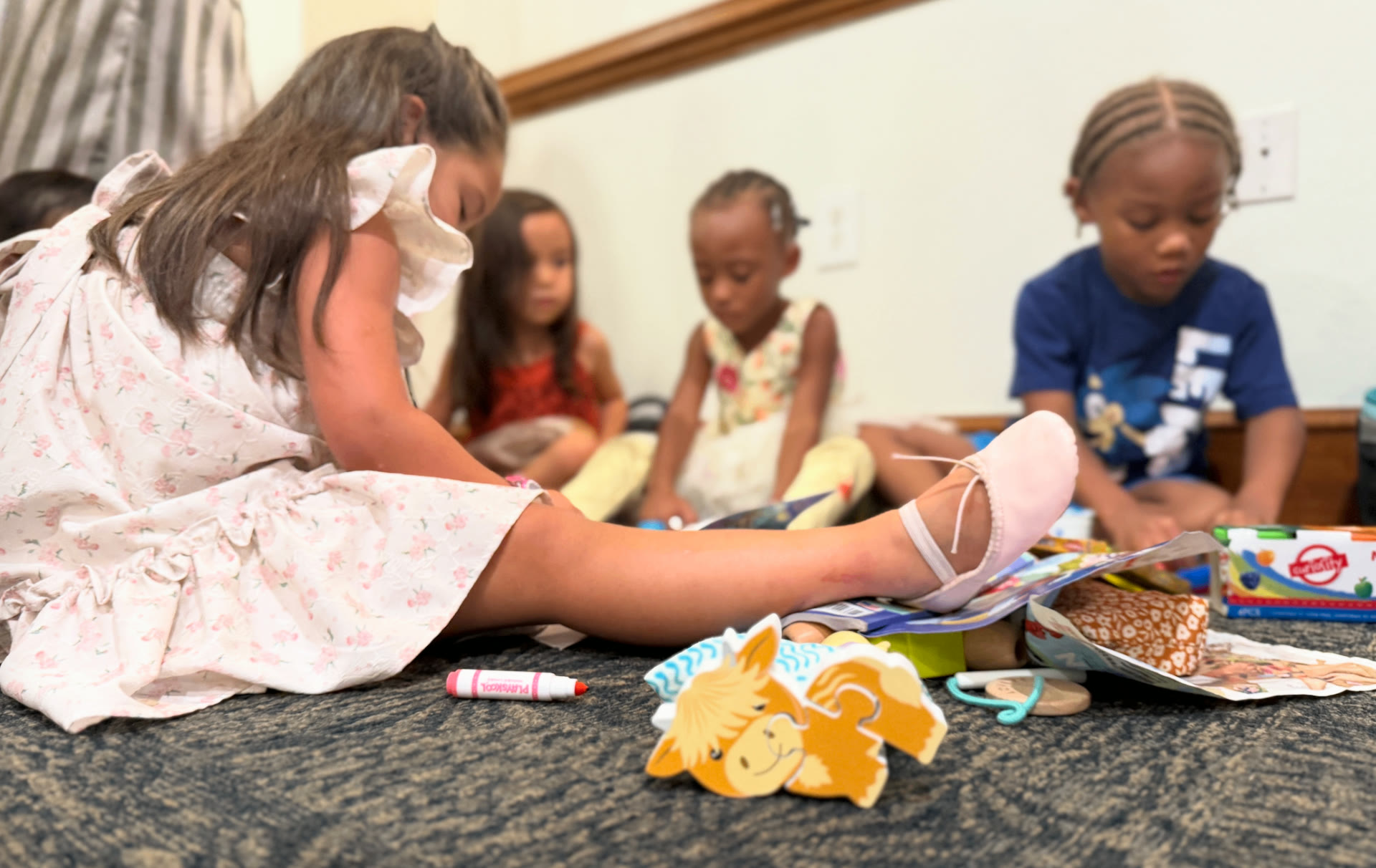 Toddlers playing together on the floor at a family event, featured in a guide to potty training tips for toddlers.
