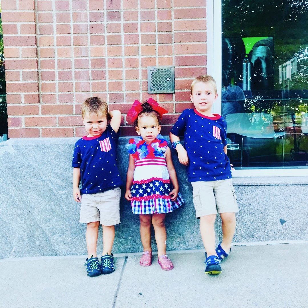 Three young children dressed in red, white, and blue, featured in a guide to choosing the right diaper size by weight.