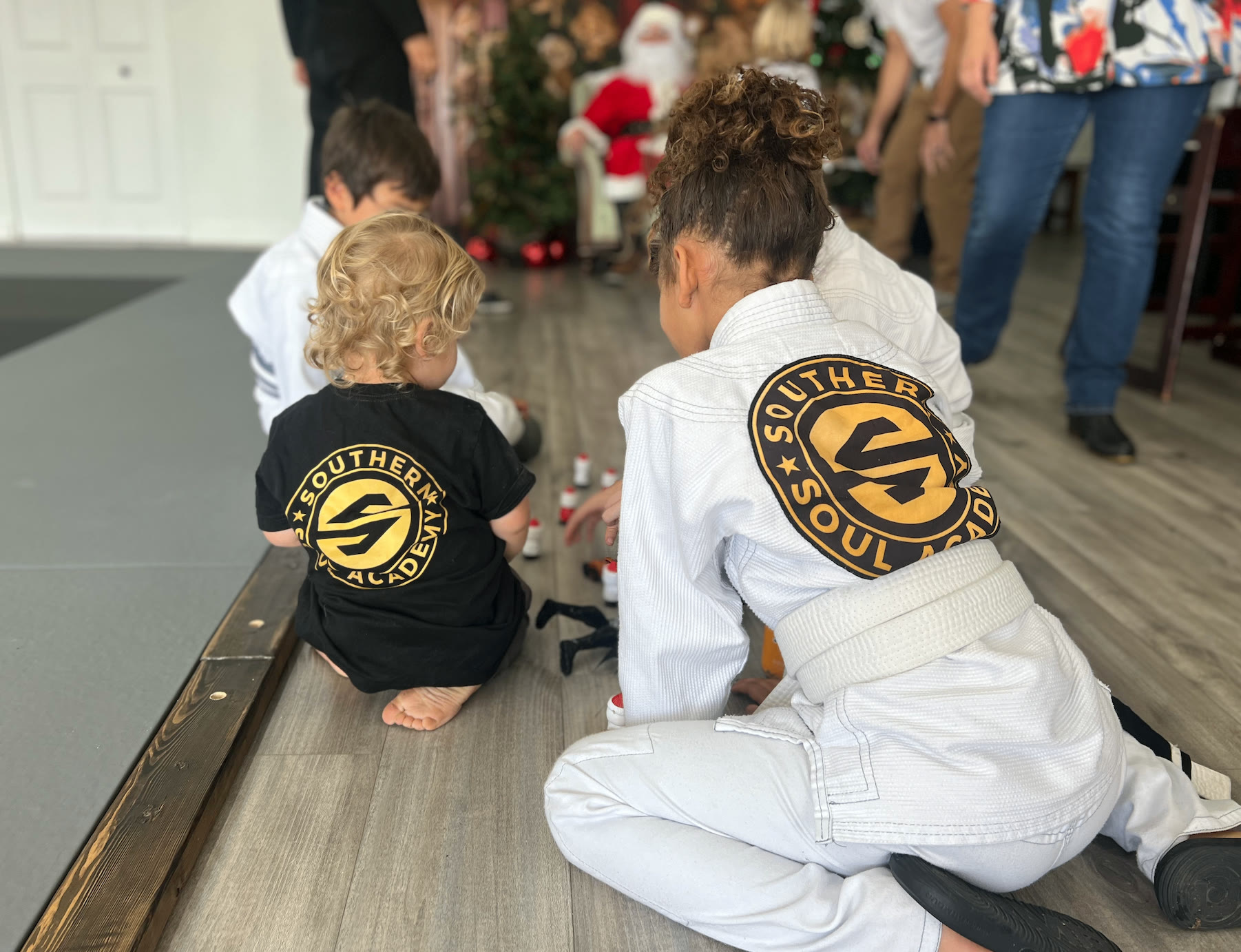Two toddlers seen from behind at a family event, featured in a guide on moving from diapers to pull-ups.