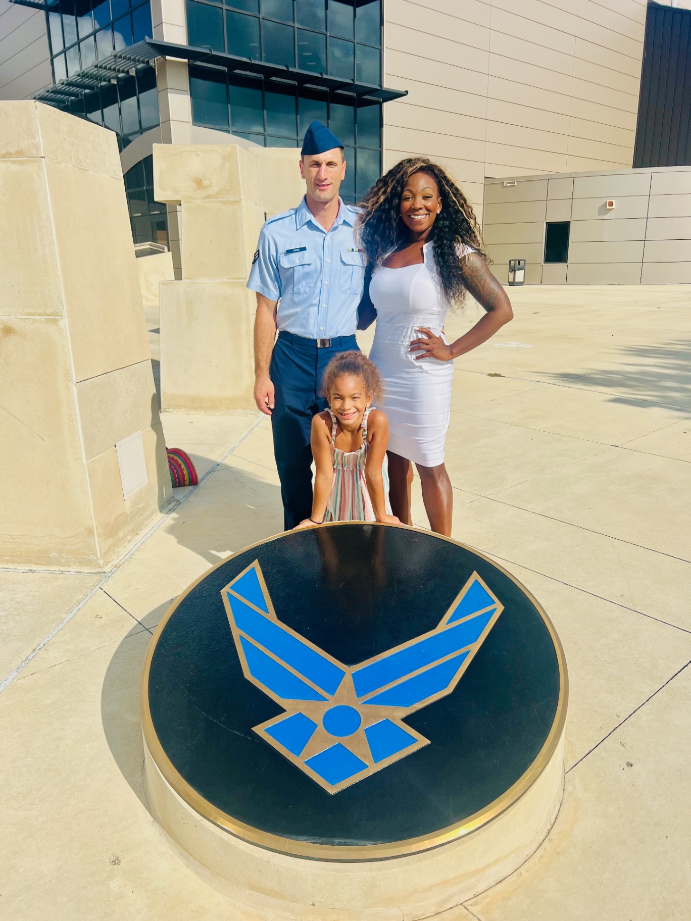 An Air Force family at a graduation standing behind the U.S. Air Force emblem, featured in a guide to Air Force family support.