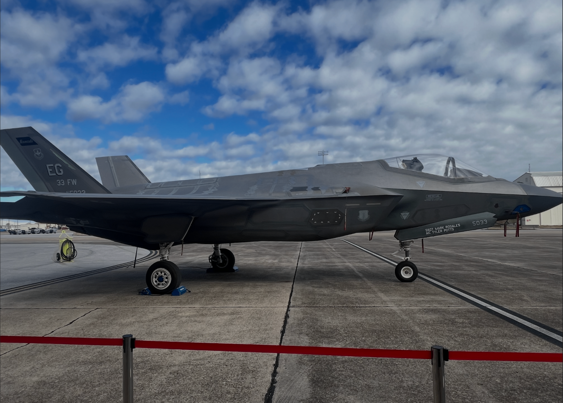 A U.S. Air Force F-35 fighter jet parked on the flight line under a blue sky.