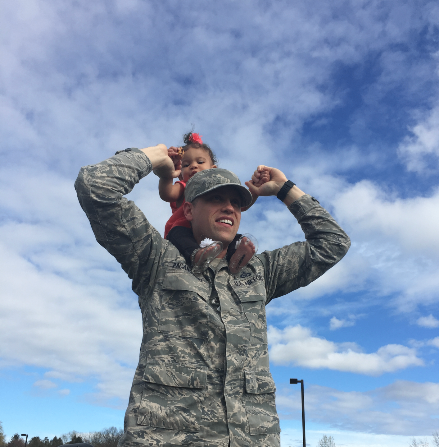 An Air Force service member carrying his young goddaughter on his shoulders, featured in a guide to whether the military CDC provides diapers.