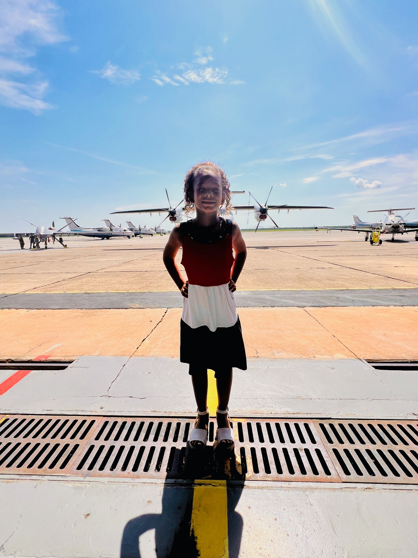 A young child standing on a military flight line in front of aircraft, featured in a guide on deployment and potty training for military families.
