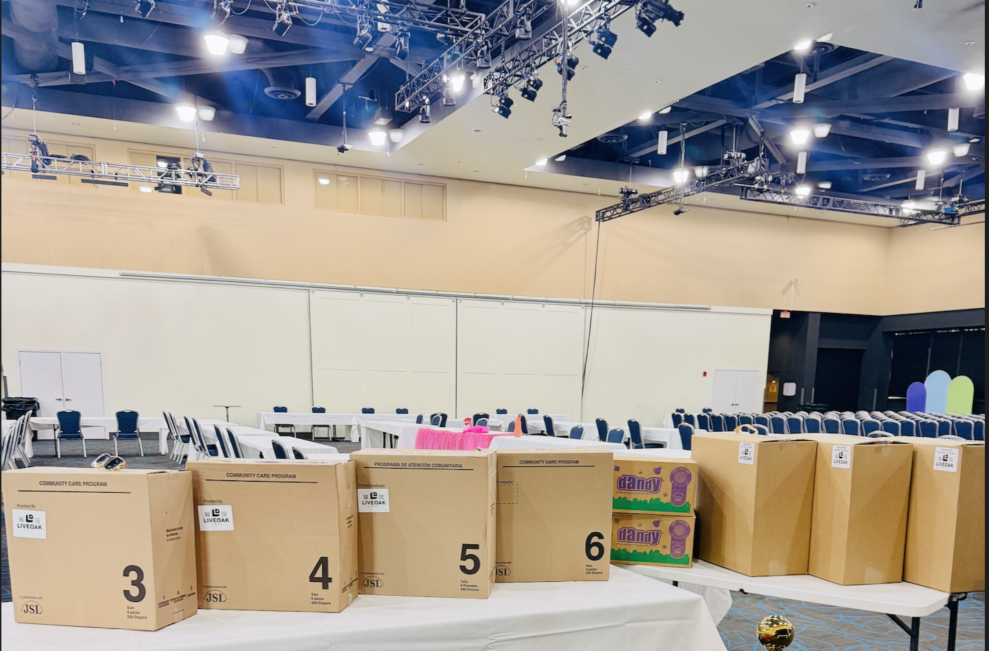 Boxes of diapers sorted by size on a table at a family distribution event