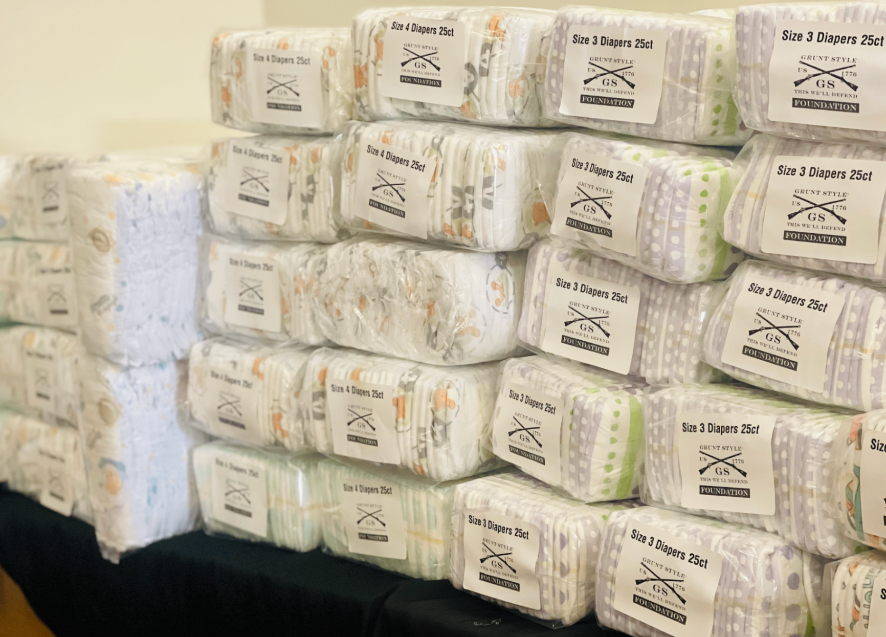 Rows of wrapped diaper packs sorted by size and stacked in bulk