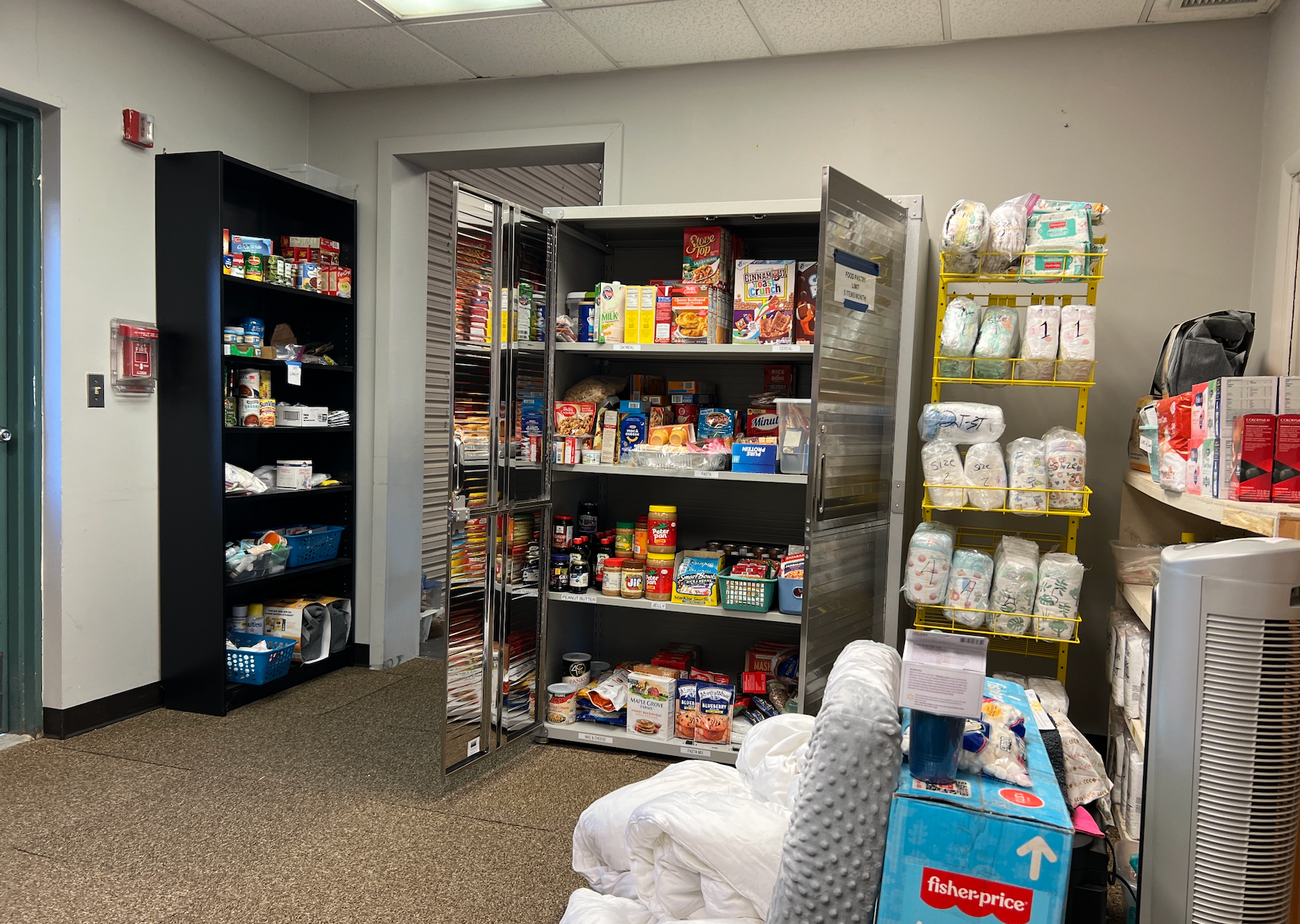 Shelves of donated food and baby diapers sorted by size at a military base family pantry
